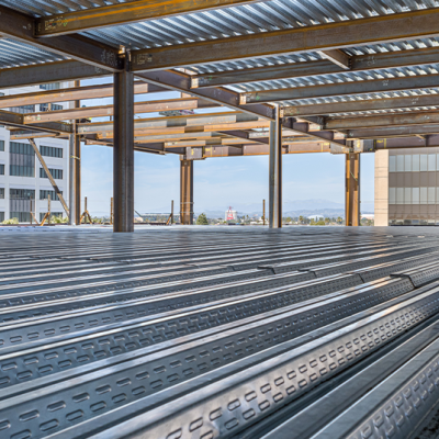 پایه‌های فلزی و اسکلت ساختمان در حال ساخت، نمایی از پروژه مهندسین مشاور عمران سازه در حال توسعه و اجرای سازه‌های بتنی و فلزی در محیط شهری.